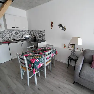 a kitchen with a table with a table cloth on it at Alaric Lodge: gîte champêtre avec parking privé. in Comigne