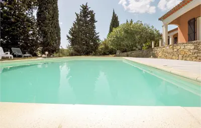 a swimming pool with blue water in front of a house at Lovely Home In Limoux in Limoux