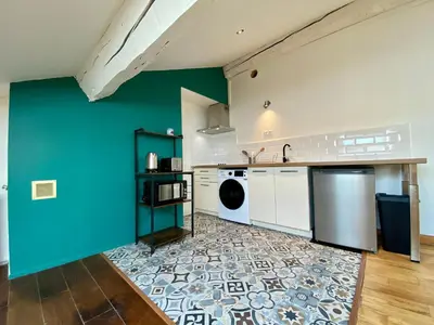 a kitchen with a blue wall and white appliances at L'Aigle d'or - Vue cité médiévale in Carcassonne