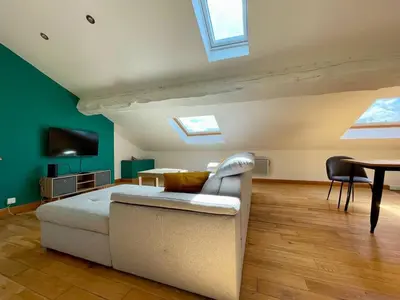a bedroom with a couch and a table and skylights at L'Aigle d'or - Vue cité médiévale in Carcassonne