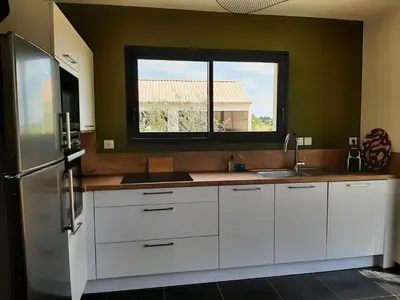 a kitchen with white cabinets and a window at Elegant Villa in Sainte Valière in Sainte-Vallière