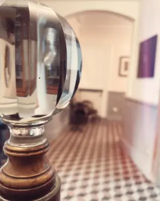 a glass vase sitting on a table in a room at L'oiseau Bleu suite MERLE BLEU in Roubia