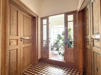 an empty hallway with doors and a tiled floor at L'oiseau Bleu suite MERLE BLEU in Roubia