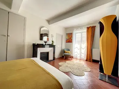 a bedroom with a bed and a fireplace at L'oiseau Bleu suite MERLE BLEU in Roubia