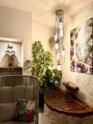a living room with a couch and a chandelier at L'oiseau Bleu suite MERLE BLEU in Roubia