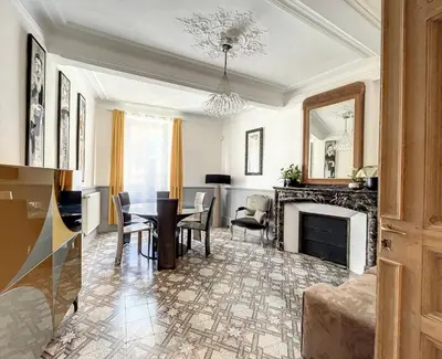 a living room with a table and a fireplace at L'oiseau Bleu suite MERLE BLEU in Roubia