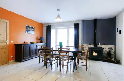a dining room with a table and chairs and a fireplace at Cecile in Montgaillard