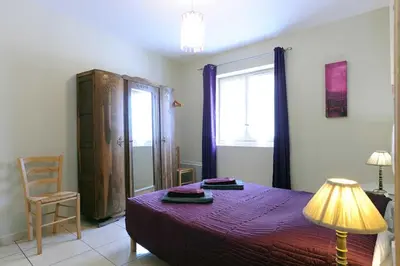 a bedroom with a bed and a lamp and a window at Cecile in Montgaillard