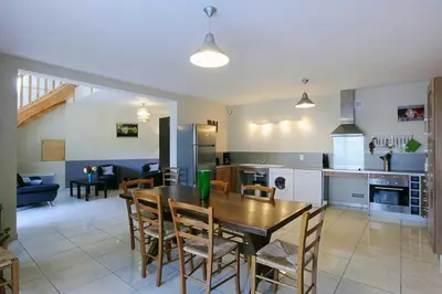 a kitchen and living room with a table and chairs at Cecile in Montgaillard