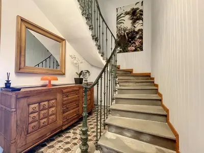 a staircase in a house with a mirror on the wall at L'oiseau Bleu FLAMANT in Roubia