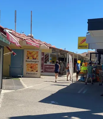 a group of people walking down a street with shops at La maison de Jade Le Mabrouka in Port-la-Nouvelle