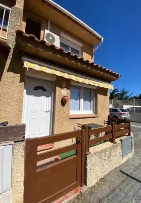 a house with a white door and a fence at La maison de Jade Le Mabrouka in Port-la-Nouvelle