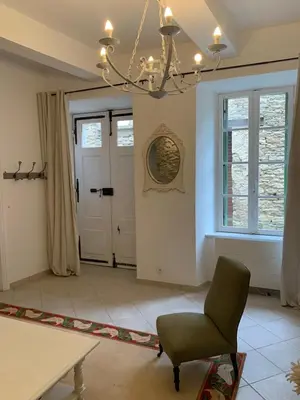 a living room with a chandelier and a chair at La Maison de Leontine in La Livinière