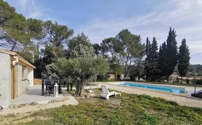 an external view of a villa with a swimming pool at La Pinède in Azillanet