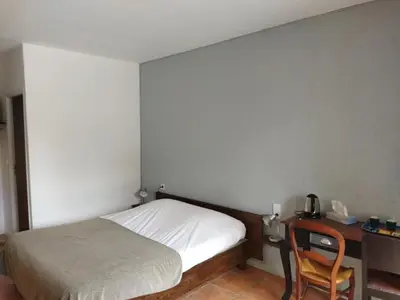 a bedroom with a bed and a desk with a chair at Aur Blan - 100m canal du midi au somail - Accueil vélo & Piscine in Le Somail