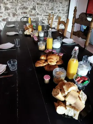 a black table with bread and bottles of orange juice at Aur Blan - 100m canal du midi au somail - Accueil vélo & Piscine in Le Somail