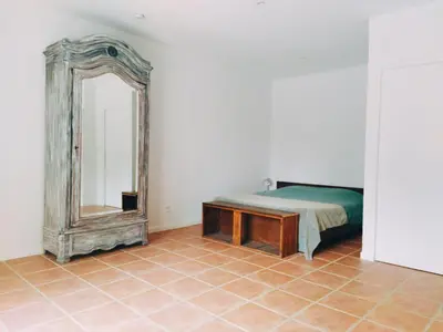 a bedroom with a bed and a mirror at Aur Blan - 100m canal du midi au somail - Accueil vélo & Piscine in Le Somail