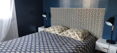a bedroom with a bed with a headboard and pillows at Joli appartement avec grande et belle terrasse, au pied de la plage du Grazel! in Gruissan