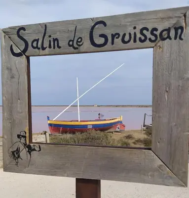 a wooden sign with a boat on the beach at Joli appartement avec grande et belle terrasse, au pied de la plage du Grazel! in Gruissan