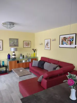 a living room with a red couch and a table at Petit Rêve des Corbières in Durban-Corbières