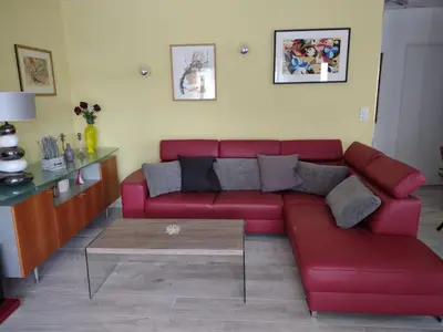 a red couch in a living room with a coffee table at Petit Rêve des Corbières in Durban-Corbières
