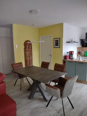 a dining room table with chairs and a kitchen at Petit Rêve des Corbières in Durban-Corbières