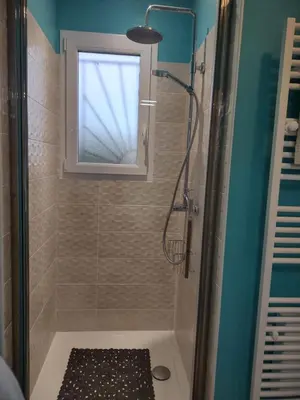 a bathroom with a shower with a window and a sink at Petit Rêve des Corbières in Durban-Corbières