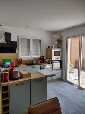 a kitchen with white cabinets and a counter top at Petit Rêve des Corbières in Durban-Corbières