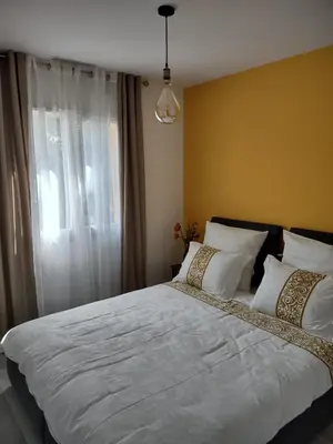 a bedroom with a large white bed with a window at Petit Rêve des Corbières in Durban-Corbières