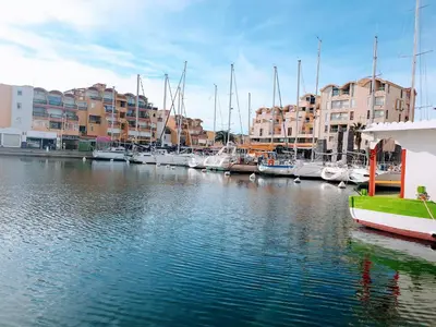 a group of boats docked in a marina with buildings at Escale à Gruissan au coeur de la Marina in Gruissan