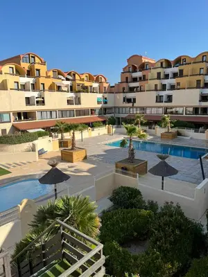 an aerial view of a resort with a swimming pool and buildings at Escale à Gruissan au coeur de la Marina in Gruissan