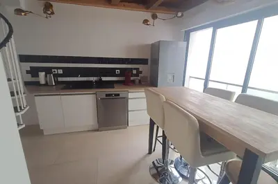 a kitchen with a wooden table and some chairs at Beau T3 au cœur du centre ville in Narbonne