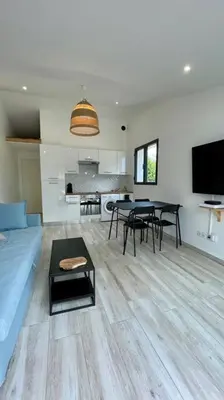 a living room with a blue couch and a table at Maisonnette chaleureuse a proximité du centre in Narbonne