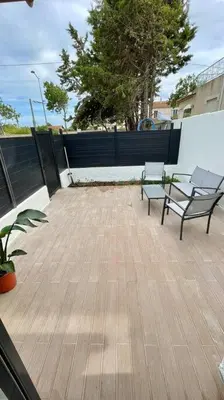a patio with two benches and a fence at Maisonnette chaleureuse a proximité du centre in Narbonne