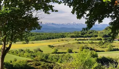 a view of a golf course with mountains in the background at Gites et Roulottes au Domaine de la Trille in Sainte-Foi