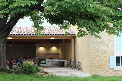 a group of people sitting at a table on a patio at Gites et Roulottes au Domaine de la Trille in Sainte-Foi