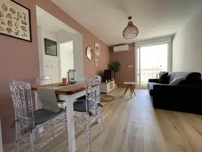 a living room with a table and chairs at T3 Expo Sud-Est - Parking - Piscine - Clim - Wifi in Gruissan