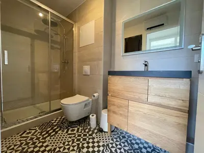 a bathroom with a toilet and a sink and a shower at T3 Expo Sud-Est - Parking - Piscine - Clim - Wifi in Gruissan