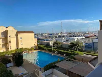 a large swimming pool with a marina in the background at T3 Expo Sud-Est - Parking - Piscine - Clim - Wifi in Gruissan