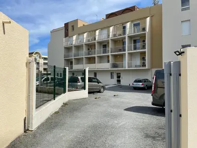 a parking lot in front of a building at T3 Expo Sud-Est - Parking - Piscine - Clim - Wifi in Gruissan