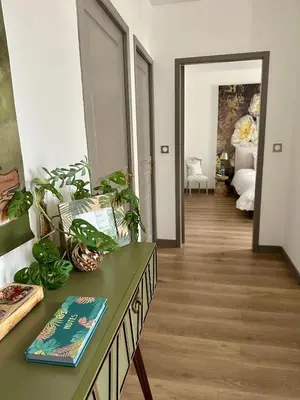 a room with a table with a book and plants at Coural' Chic in Narbonne