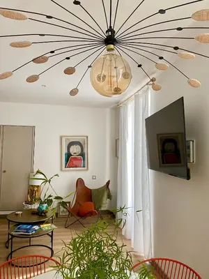 a living room with a ceiling with a chandelier at Coural' Chic in Narbonne