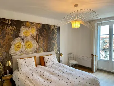 a bedroom with a bed with flowers on the wall at Coural' Chic in Narbonne