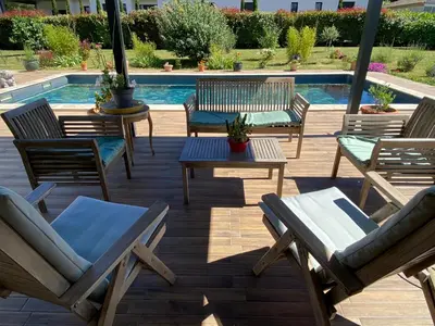 a patio with chairs and tables and a pool at La Rosela de la Cité in Palaja