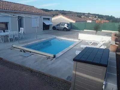 a swimming pool in a yard next to a house at Maison individuelle neuve avec piscine in Limoux