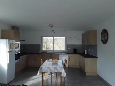 a kitchen with a table and a white refrigerator at Maison individuelle neuve avec piscine in Limoux