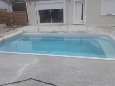 a swimming pool with blue water in a driveway at Maison individuelle neuve avec piscine in Limoux