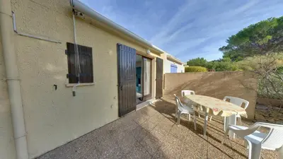 a patio with a table and chairs and a building at Gruissan: Maisonnette T2 avec jardin in Gruissan