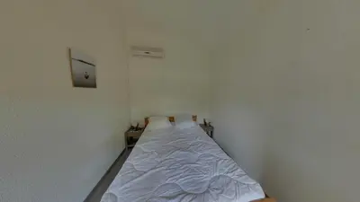 a small white room with a bed in it at Gruissan: Maisonnette T2 avec jardin in Gruissan