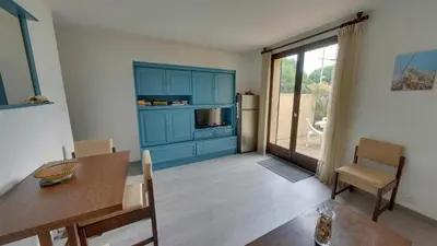 a living room with a table and a blue cabinet at Gruissan: Maisonnette T2 avec jardin in Gruissan